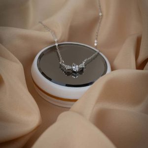 Collar plateado con dije brillante de corazón y alas de ángel desplegadas