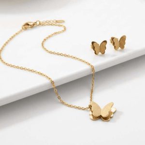 Set de joyería dorada compuesto por collar con dije de mariposa y aretes de botón a juego