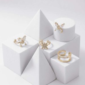 Set de pendientes y ear cuffs dorados con diseño de mariposa y estrellas con zirconias