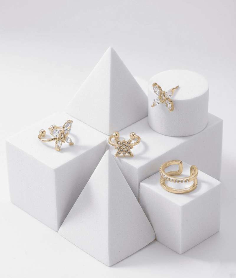 Set de pendientes y ear cuffs dorados con diseño de mariposa y estrellas con zirconias