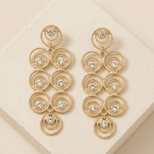 Pendientes dorados largos articulados formados por círculos concéntricos texturizados con cristales centrales