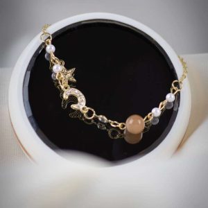 Pulsera dorada ajustable con dijes de luna creciente con zirconias, estrella y esfera de cuarzo