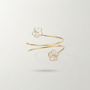 Brazalete dorado de diseño abierto con detalles florales perlados en los extremos